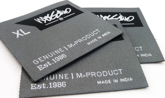 label, clothing label, woven label, tag, gray clothes, clothing label, clothing label, woven label, woven label, woven label, woven label, woven label. Använd produkttaggar utan att störa förståelsen